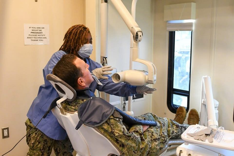 Dentist examining a patient, which helps tell sinus tooth pain apart from a dental problem