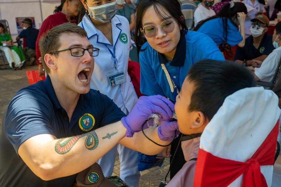 Volunteer dental team treating a young patient at a community dental event