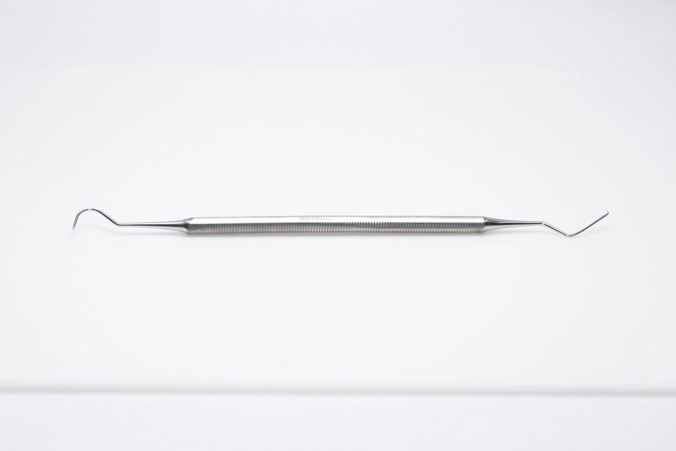 Dental hand instrument of the kind used to shape a tooth-colored filling on a front tooth