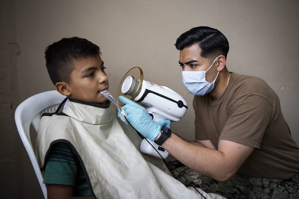 Dental team examining a patient's mouth before gum treatment