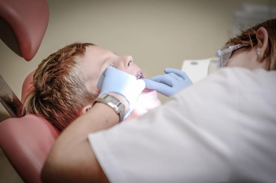 Dentist examining a numbed patient in the dental chair
