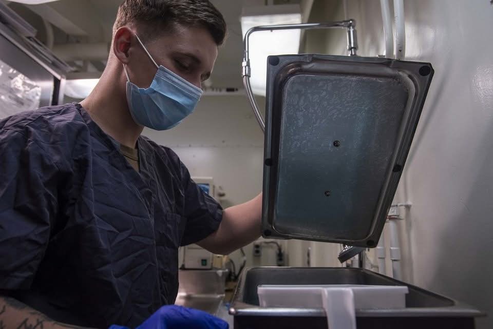 Dental assistant preparing sterilized instruments before a tooth extraction