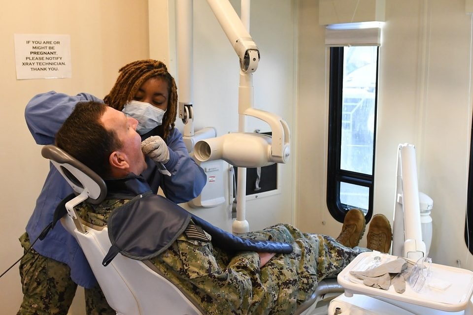 Dentist checking a patient, the first step in finding why a tooth crown hurts
